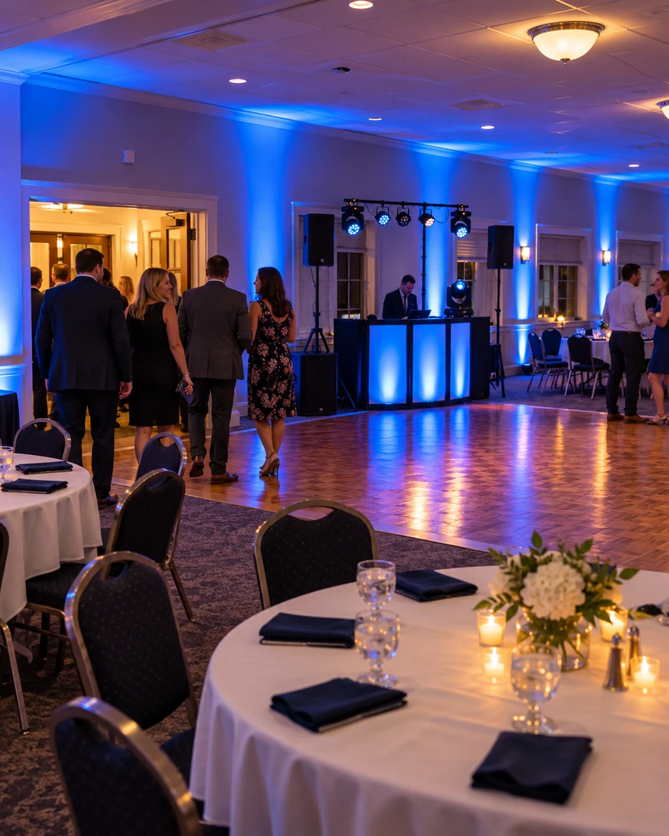 Blue uplighting and a compact DJ setup in a banquet hall